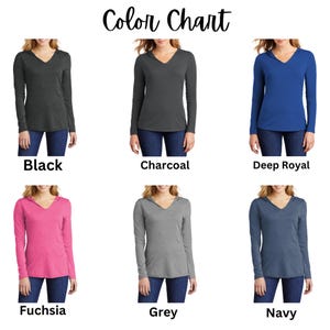 May include: Color chart showing six different colors of long-sleeved hooded shirts. The colors are black, charcoal, deep royal, fuchsia, grey, and navy.
