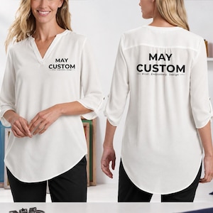 May include: A white blouse with three-quarter length sleeves and a V-neckline. The front features the black text MAY CUSTOM Print . Embroidery . Design. The back displays the same black text in a larger size across the upper back area.