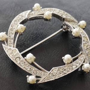 Clear rhinestone and pearl circle brooch.