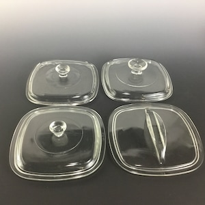 May include: Four square glass lids with handles. Three lids have a single knob handle, and one lid has a long, thin handle.