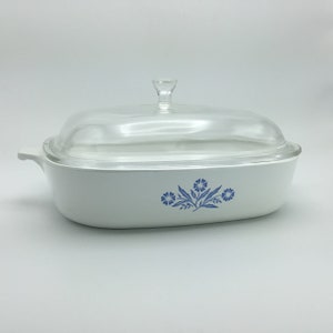 May include: White oval casserole dish with a glass lid and a blue floral design.