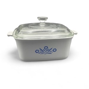 May include: White casserole dish with a glass lid and a blue floral design.