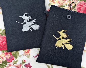 Broderad bokomslag med flygande häxa på kvast