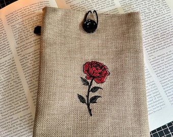 Broderad bokomslag med enkel röd ros