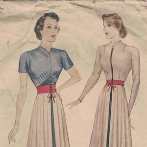 May include: Vintage Simplicity pattern 2718 featuring illustrations of dresses. The dresses have a fitted bodice, a cinched waist with a contrasting belt, and a flared skirt. The pattern includes the text "Simplicity Pattern" and "Made in U.S.A."