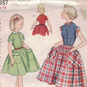 May include: Vintage Simplicity pattern 4387, size 10, featuring illustrations of three different dresses. The dresses include a green dress with pockets, a red dress, and a blue and red plaid dress. The pattern details are printed on each piece.