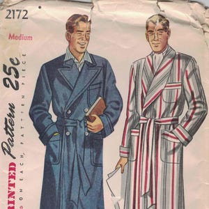 May include: Vintage Simplicity pattern 2172 featuring illustrations of two men's robes. One is a double-breasted blue robe with a belt, the other is a striped robe with red and white stripes. The pattern is marked "Medium".