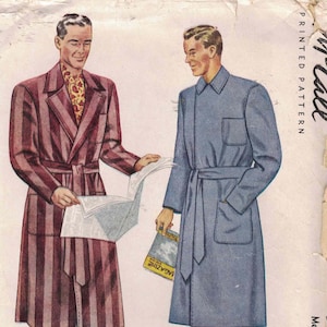 May include: A vintage McCall printed pattern envelope for a robe, featuring an illustration of two figures wearing long-sleeved, belted robes. One robe is burgundy with dark vertical stripes, and the other is solid blue with a chest pocket.