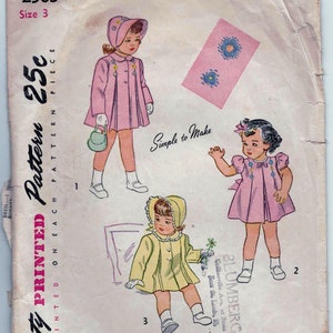 May include: A vintage Simplicity sewing pattern for a child's dress. The pattern is for size 3 and costs 25 cents. The pattern includes instructions for making a dress with a Peter Pan collar and puffed sleeves. The pattern also includes a bonnet.