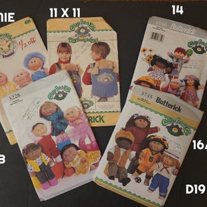 May include: A collection of vintage Cabbage Patch Kids sewing patterns, showcasing illustrations of the dolls in different outfits. The patterns are labelled with sizes and brand names, including Butterick. The image includes the text "PREMIE", "11 X 11", "13", "14", "16/21", and "D19".
