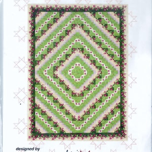May include: Quilt pattern for a "Ripples" quilt, designed by Jackie Robinson. The pattern includes instructions for making a lap, twin, queen, or king size quilt. The pattern includes a tool. The quilt features a green and pink design with a diamond pattern.