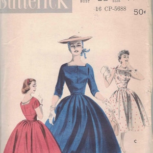 May include: Vintage Butterick sewing pattern envelope featuring illustrations of women's dresses. The envelope is cream-colored with the number 7601 and bust size 32, size 14 printed on it. The illustrations depict dresses in red, blue, and floral patterns.