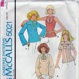 May include: A sewing pattern for a set of tops with blue transfer for embroidery. The pattern is for misses' sizes and includes four different styles of tops. The pattern is from McCall's and is number 5021.