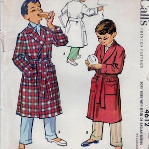 Puede incluir: Un patrón de costura vintage para una bata de niño con mangas de encaje o raglan. El patrón es de McCall's y es el número 4612. El patrón muestra a dos niños usando diferentes batas, una en cuadros rojos y blancos y la otra en rojo sólido.