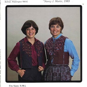 May include: A sewing pattern titled Wash and Flair Vest, Pattern P1027 by Nancy J. Martin, 1983. The cover features two vests with textured, layered fabric embellishments on the front panels, shown in dark blue and maroon colors over shirts.