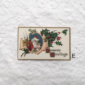 May include: Vintage Christmas postcard featuring a cartoon Santa Claus holding a doll, with candles and holly leaves surrounding him. The text "Season's Greetings" is printed in the bottom right corner.