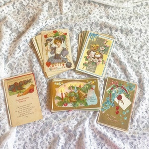 May include: Assortment of vintage postcards featuring holiday greetings. The postcards are decorated with illustrations of flowers, birds, and bells. The text on the postcards includes "Thanksgiving Wishes", "My very best wishes are reserved for you on Thanksgiving Day", "Christmas", "Loving Friends Wishes", and "New Year Greetings".