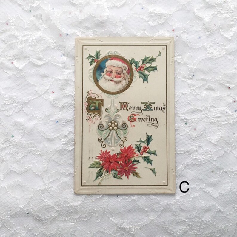 May include: Vintage Christmas postcard featuring a portrait of Santa Claus in a red hat and white beard, surrounded by holly and poinsettia flowers. The text "Merry Xmas Greeting" is written in cursive.