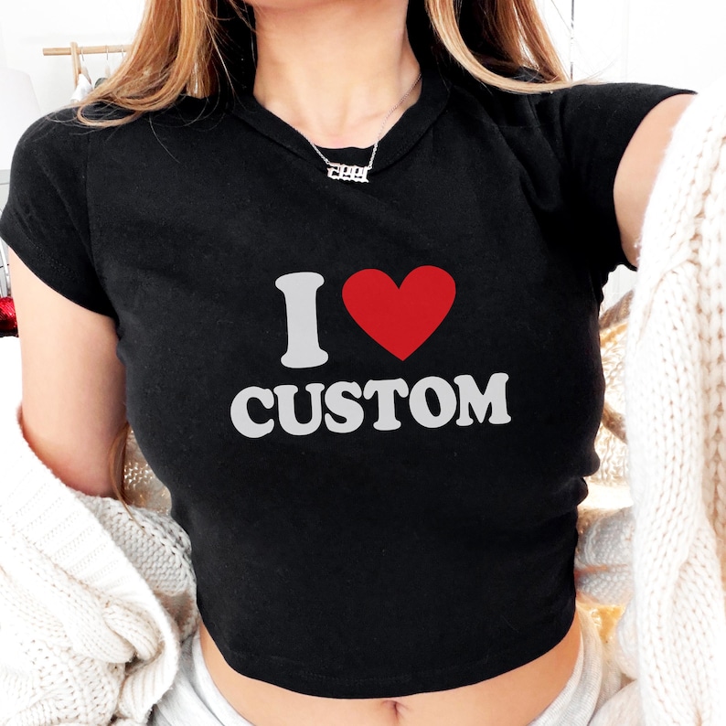 May include: Black crop top with the text "I ♥ CUSTOM" in white and a red heart. The shirt has short sleeves and a crew neck. The top is made of a soft material.