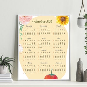 May include: A printable calendar for 2022 with a yellow background and watercolor illustrations of flowers, a sunflower, a bird, and a tomato. The months are listed in a grid format with the days of the week labeled.