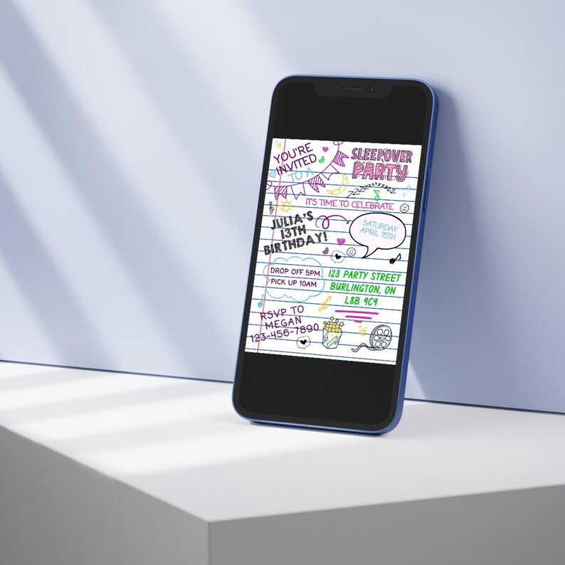 May include: A smartphone displaying a digital sleepover party invitation on a lined notebook background. The text reads: You're invited to a sleepover party, Julia's 13th birthday, Saturday April 15th, drop off 5pm, pick up 10am, 123 Party Street, Burlington, ON, L8B 9C9, RSVP to Megan 123-456-7890.