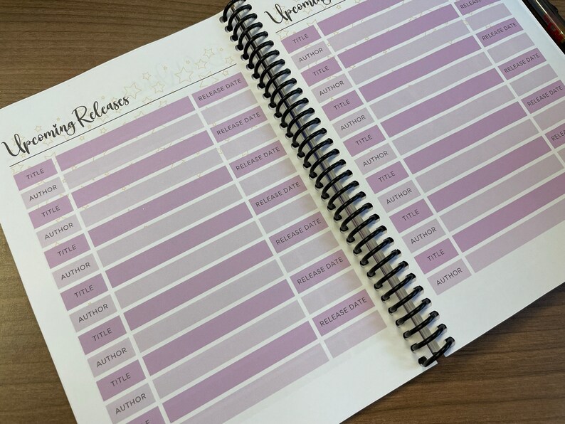 Puede incluir: Primer plano de un libro con un dise&ntilde;o morado y blanco. El libro tiene una encuadernaci&oacute;n en espiral y est&aacute; abierto en una p&aacute;gina con una lista de lanzamientos pr&oacute;ximos. La lista incluye columnas para el t&iacute;tulo, el autor y la fecha de lanzamiento.