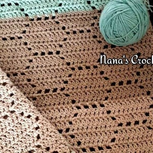 May include: A beige crochet blanket featuring a geometric openwork pattern and a light mint green border, accompanied by two matching mint green yarn balls. The text Nana's Crochet Creations is printed in white on the fabric surface.