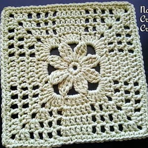 May include: A crocheted square with a flower design in the center. The square is made with a light green yarn and has a delicate, lacy look. "Nana's Crochet Creations" is written in the top right corner of the image.