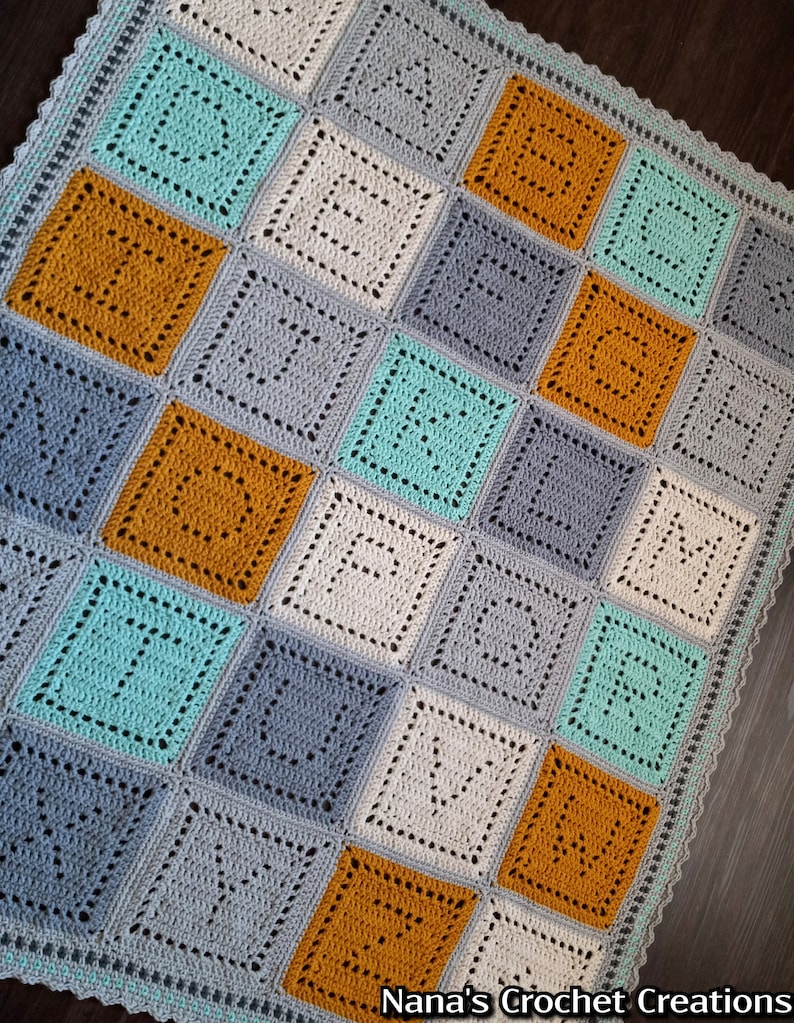 May include: A crocheted baby blanket with a square pattern in shades of gray, teal, and mustard yellow. The blanket has a scalloped edge.