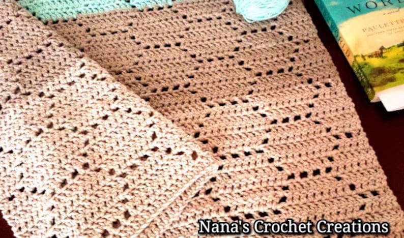 May include: A beige crochet blanket featuring a repeating hexagonal pattern with openwork stitches. The blanket has a light mint green border at the top edge. The text Nana's Crochet Creations is printed in the bottom right corner of the image.