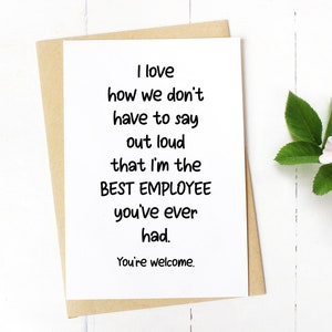 May include: A white greeting card with black text that reads: I love how we don't have to say out loud that I'm the BEST EMPLOYEE you've ever had. You're welcome. The card is placed on top of a tan envelope, accompanied by a single white and pink flower.
