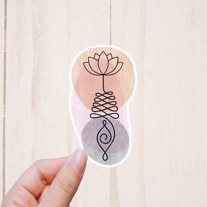 May include: A sticker with a black line drawing of a lotus flower with a swirling design below it. The background is a watercolor wash of pink, orange, and gray.