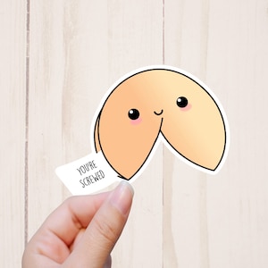 May include: A cartoon fortune cookie sticker with a smiling face and the text "You're Screwed" on the fortune paper.
