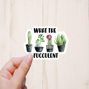 May include: A white sticker with a black and white illustration of four potted succulents. The text "What the Fuc*culent" is printed below the succulents.