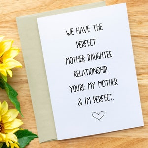 May include: A white card with black text that reads "We have the perfect mother daughter relationship. You're my mother & I'm perfect."  A small heart is drawn at the bottom of the card.
