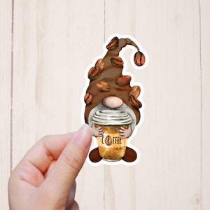 May include: A brown coffee gnome sticker with a coffee cup that says "Coffee" on it. The gnome's hat is decorated with coffee beans.