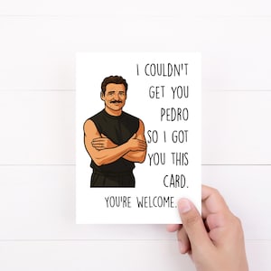 May include: A white greeting card with the text "I couldn't get you Pedro so I got you this card. You're welcome." An illustration of a man with crossed arms is on the card.