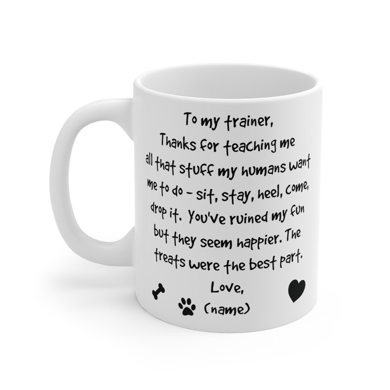 Puede incluir: Taza de caf&eacute; de cer&aacute;mica blanca con un mensaje escrito a mano en negro que dice "A mi entrenador, Gracias por ense&ntilde;arme todo eso que mis humanos quieren que haga - si&eacute;ntate, qu&eacute;date, tal&oacute;n, ven, suelta. Has arruinado mi diversi&oacute;n, pero ellos parecen m&aacute;s felices. Las golosinas fueron la mejor parte. Amor, (nombre)" con una huella de pata, un hueso y un coraz&oacute;n gr&aacute;fico.