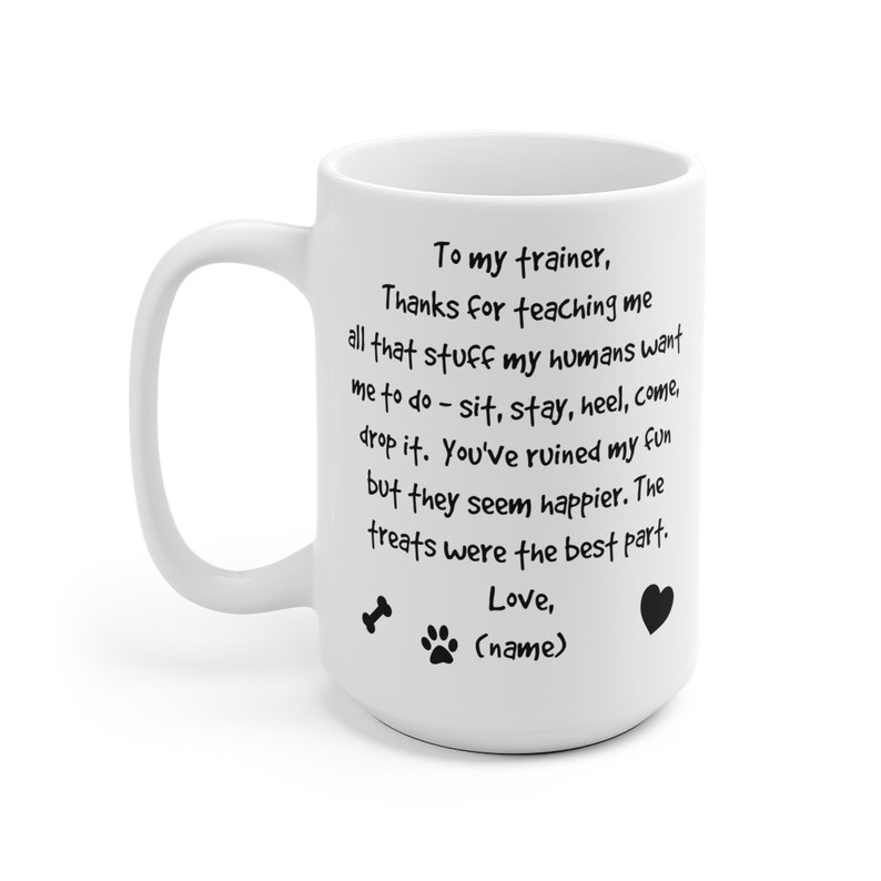 Puede incluir: Taza de caf&eacute; de cer&aacute;mica blanca con un mensaje escrito a mano en negro que dice "A mi entrenador, Gracias por ense&ntilde;arme todo eso que mis humanos quieren que haga - sentarse, quedarse, tal&oacute;n, venir, soltar. Has arruinado mi diversi&oacute;n, pero ellos parecen m&aacute;s felices. Las golosinas fueron la mejor parte. Amor, (nombre)" con un hueso, una huella de pata y un coraz&oacute;n.