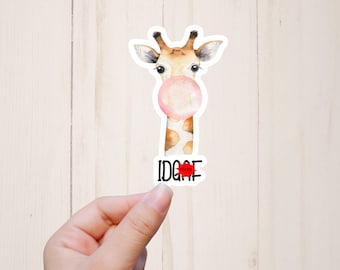 Könnte beinhalten: Ein Aufkleber mit einer Giraffe, die eine rosa Blase ausbläst. Die Giraffe hat einen braunen und weißen gemusterten Hals und einen schwarzen Text, der "IDGAF" mit einem roten Herzen sagt.