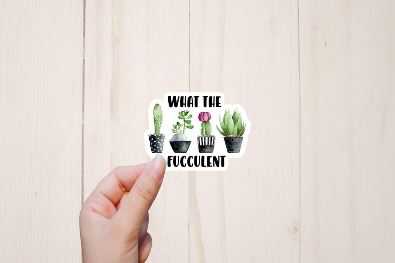 May include: A white sticker with a black and white illustration of four potted succulents. The text "What the Fuc*culent" is printed below the succulents.