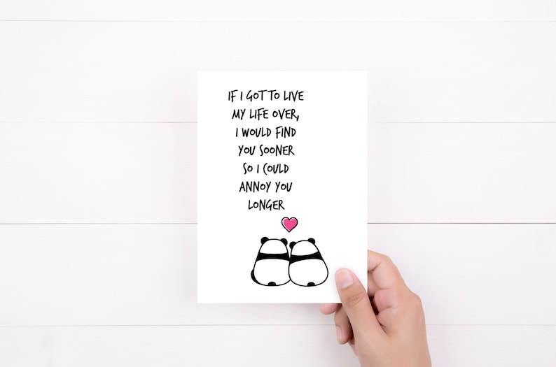 Op de afbeelding: Een witte kaart met de tekst "IF I GOT TO LIVE MY LIFE OVER, I WOULD FIND YOU SOONER SO I COULD ANNOY YOU LONGER." Twee panda-illustraties en een roze hart staan ook op de kaart.