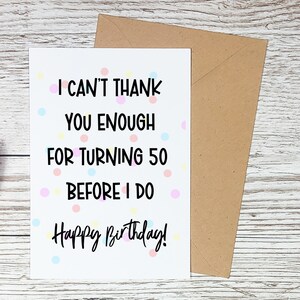Może przedstawiać: Biała kartka urodzinowa z napisem "I CAN'T THANK YOU ENOUGH FOR TURNING 50 BEFORE I DO Happy Birthday!" obok brązowej koperty. Karta ma kolorowe kropki.