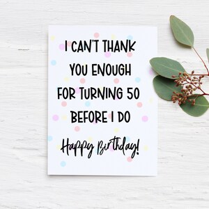 Może przedstawiać: Biała kartka urodzinowa z napisem "I CAN'T THANK YOU ENOUGH FOR TURNING 50 BEFORE I DO Happy Birthday!" otoczona jest kolorowymi kropkami. Gałązka zielonych liści i małych brązowych pąk&oacute;w znajduje się w prawym g&oacute;rnym rogu.
