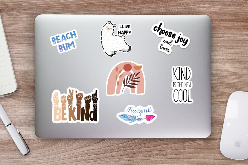 May include: A laptop computer with several stickers on it. The stickers feature various designs and phrases, including a llama, a rainbow, a feather, and the words "Beach Bum", "Llive Happy", "Choose Joy and Tacos", "Be Kind", "Kind is the New Cool", and "Free Spirit".