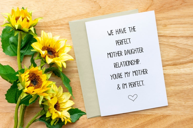 May include: A white card with black text that reads "We have the perfect mother daughter relationship. You're my mother & I'm perfect."  A small heart is drawn at the bottom of the card.