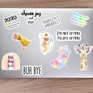 May include: A collection of colorful stickers featuring various designs and phrases, including a rainbow with the text "Best Day Ever", a yellow duckling with flowers, a giraffe with a flower crown, a hand with the text "Perfectly Imperfect", and the text "Choose Joy and Pizza".
