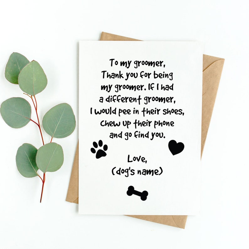 May include: A white greeting card with black text, a paw print, a heart, and a dog bone illustration. The card is in a brown envelope and has a sprig of green leaves. The text reads: "To my groomer, Thank you for being my groomer..."