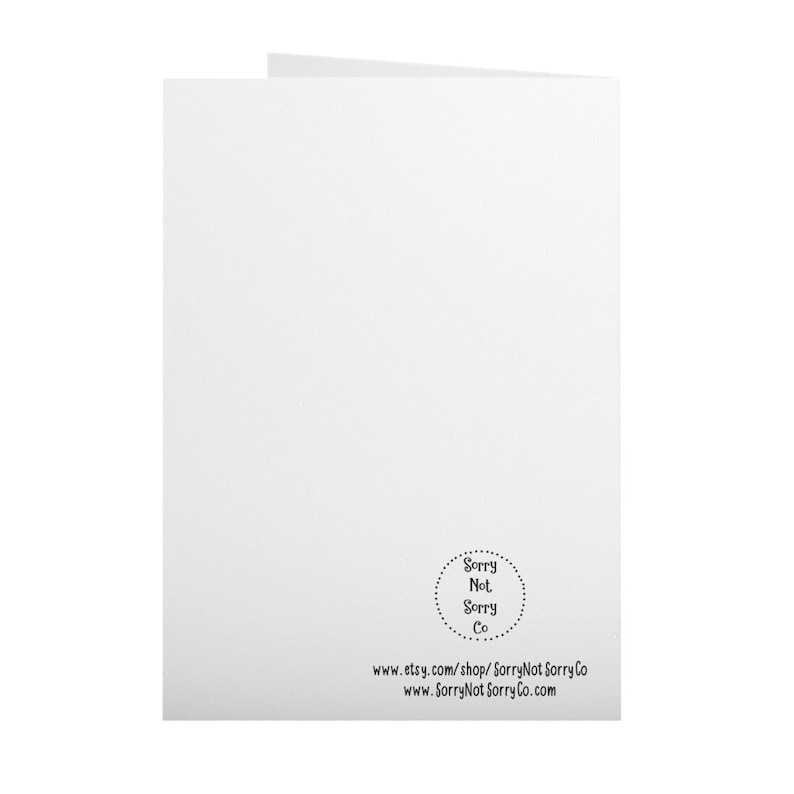 Op de afbeelding: Een gevouwen witte wenskaart met de tekst "Sorry Not Sorry Co" in een cirkelvormig ontwerp rechtsonder. De kaart bevat ook het websiteadres www.etsy.com/shop/SorryNotSorryCo en www.SorryNotSorryCo.com.