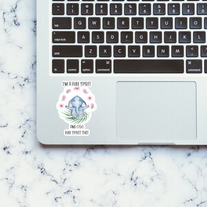 May include: A sticker with a cartoon elephant meditating with pink flowers around it. The sticker says "I'm a free spirit and I do free spirit shit."